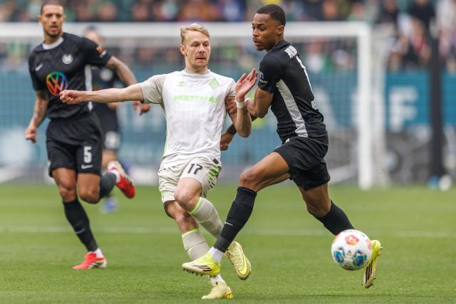 21 March 2026, Lower Saxony, Wolfsburg: Werder Bremen's Marco Gruell and Wolfsburg's Jeanuel Belocian (R) battle for the ball during the German Bundesliga soccer match between VfL Wolfsburg and SV Werder Bremen at Volkswagen Arena. Photo: Andreas Gora/dpa - WICHTIGER HINWEIS: Gemäß den Vorgaben der DFL Deutsche Fußball Liga bzw. des DFB Deutscher Fußball-Bund ist es untersagt, in dem Stadion und/oder vom Spiel angefertigte Fotoaufnahmen in Form von Sequenzbildern und/oder videoähnlichen Fotostrecken zu verwerten bzw. verwerten zu lassen.