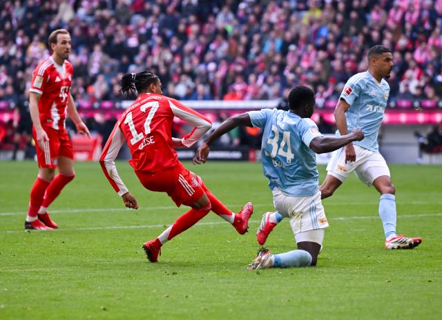 21 March 2026, Bavaria, Munich: Bayern Munich's Michael Olise (2nd L) scores his side's first goal during the German Bundesliga soccer match between Bayern Munich and 1. FC Union Berlin at the Allianz Arena. Photo: Sven Hoppe/dpa - WICHTIGER HINWEIS: Gemäß den Vorgaben der DFL Deutsche Fußball Liga bzw. des DFB Deutscher Fußball-Bund ist es untersagt, in dem Stadion und/oder vom Spiel angefertigte Fotoaufnahmen in Form von Sequenzbildern und/oder videoähnlichen Fotostrecken zu verwerten bzw. verwerten zu lassen.