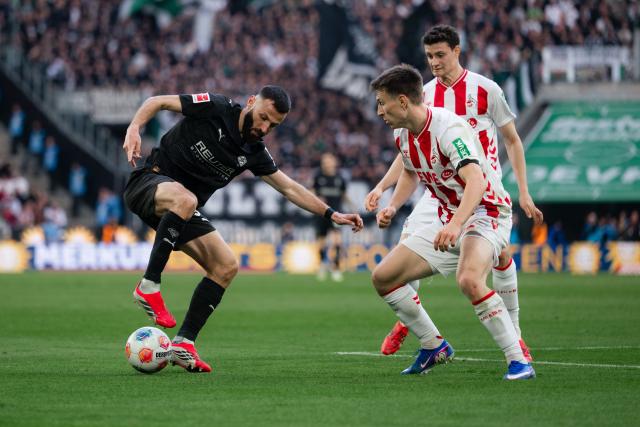 21 March 2026, North Rhine-Westphalia, Cologne: Cologne's Kristoffer Lund (R) and Gladbach's Franck Honorat battle for the ball during the German Bundesliga soccer match between 1. FC Cologne and Borussia Moenchengladbach at RheinEnergieStadion. Photo: Marius Becker/dpa - WICHTIGER HINWEIS: Gemäß den Vorgaben der DFL Deutsche Fußball Liga bzw. des DFB Deutscher Fußball-Bund ist es untersagt, in dem Stadion und/oder vom Spiel angefertigte Fotoaufnahmen in Form von Sequenzbildern und/oder videoähnlichen Fotostrecken zu verwerten bzw. verwerten zu lassen.