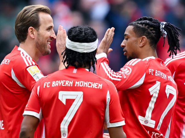21 March 2026, Bavaria, Munich: Bayern Munich's Harry Kane (L) celebrates scoring his side's third goal with teammates Serge Gnabry (C) and Michael Olise during the German Bundesliga soccer match between Bayern Munich and 1. FC Union Berlin at the Allianz Arena. Photo: Sven Hoppe/dpa - WICHTIGER HINWEIS: Gemäß den Vorgaben der DFL Deutsche Fußball Liga bzw. des DFB Deutscher Fußball-Bund ist es untersagt, in dem Stadion und/oder vom Spiel angefertigte Fotoaufnahmen in Form von Sequenzbildern und/oder videoähnlichen Fotostrecken zu verwerten bzw. verwerten zu lassen.