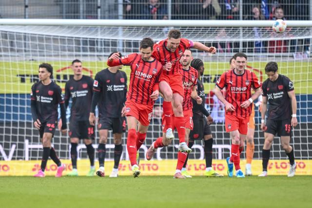 21 March 2026, Baden-Wuerttemberg, Heidenheim: Heidenheim's Marvin Pieringer (L) celebrates scoring his side's third goal with teammates Patrick Mainka during the German Bundesliga soccer match between 1. FC Heidenheim and Bayer Leverkusen at Voith-Arena. Photo: Harry Langer/dpa - WICHTIGER HINWEIS: Gemäß den Vorgaben der DFL Deutsche Fußball Liga bzw. des DFB Deutscher Fußball-Bund ist es untersagt, in dem Stadion und/oder vom Spiel angefertigte Fotoaufnahmen in Form von Sequenzbildern und/oder videoähnlichen Fotostrecken zu verwerten bzw. verwerten zu lassen.