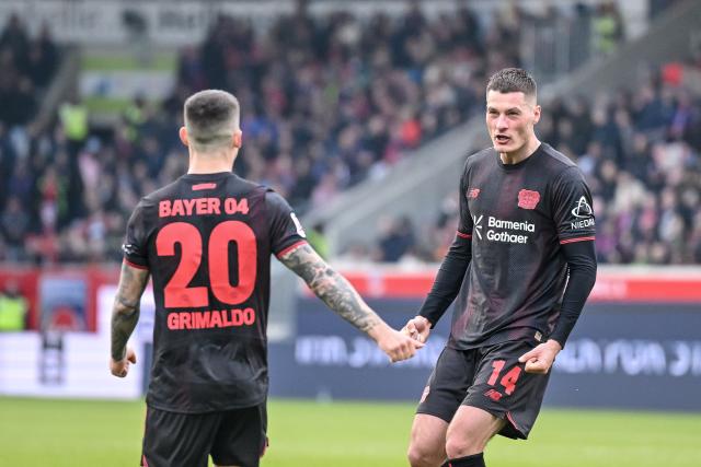 21 March 2026, Baden-Wuerttemberg, Heidenheim: Leverkusen's Patrik Schick (R) celebratea scoring his side's third goal with teammate  Alex Grimaldo during the German Bundesliga soccer match between 1. FC Heidenheim and Bayer Leverkusen at Voith-Arena. Photo: Harry Langer/dpa - WICHTIGER HINWEIS: Gemäß den Vorgaben der DFL Deutsche Fußball Liga bzw. des DFB Deutscher Fußball-Bund ist es untersagt, in dem Stadion und/oder vom Spiel angefertigte Fotoaufnahmen in Form von Sequenzbildern und/oder videoähnlichen Fotostrecken zu verwerten bzw. verwerten zu lassen.