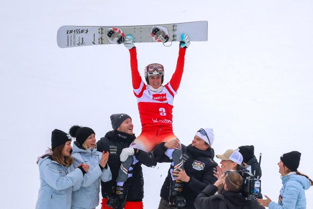 21 March 2026, North Rhine-Westphalia, Winterberg: Swiss snowboarder Julie Zogg is carried on the shoulders of her teammates after the Women's Parallel Slalom of the FIS Snowboard World Cup in Winterberg. Photo: Christoph Reichwein/dpa