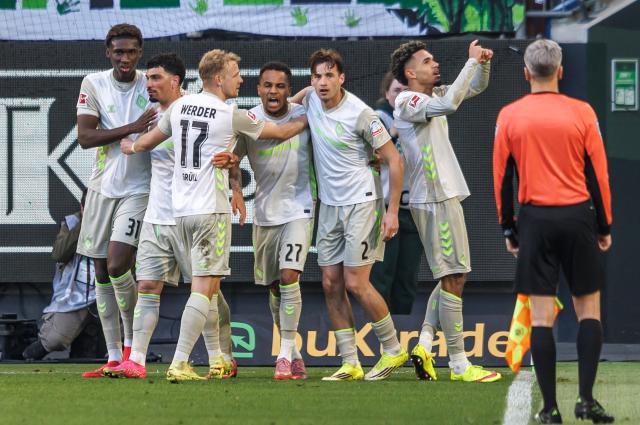 21 March 2026, Lower Saxony, Wolfsburg: Werder Bremen's Justin Njinmah (R) celebrates scoring his side's first goal with teammates during the German Bundesliga soccer match between VfL Wolfsburg and SV Werder Bremen at Volkswagen Arena. Photo: Andreas Gora/dpa - WICHTIGER HINWEIS: Gemäß den Vorgaben der DFL Deutsche Fußball Liga bzw. des DFB Deutscher Fußball-Bund ist es untersagt, in dem Stadion und/oder vom Spiel angefertigte Fotoaufnahmen in Form von Sequenzbildern und/oder videoähnlichen Fotostrecken zu verwerten bzw. verwerten zu lassen.