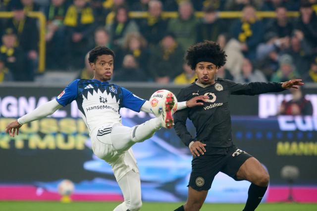 21 March 2026, North Rhine-Westphalia, Dortmund: Hamburger's Warmed Omari (L) and Borussia Dortmund's Karim Adeyemi battle for the ball during the German Bundesliga soccer match between Borussia Dortmund and Hamburger SV at Signal Iduna Park. Photo: Bernd Thissen/dpa - WICHTIGER HINWEIS: Gemäß den Vorgaben der DFL Deutsche Fußball Liga bzw. des DFB Deutscher Fußball-Bund ist es untersagt, in dem Stadion und/oder vom Spiel angefertigte Fotoaufnahmen in Form von Sequenzbildern und/oder videoähnlichen Fotostrecken zu verwerten bzw. verwerten zu lassen.