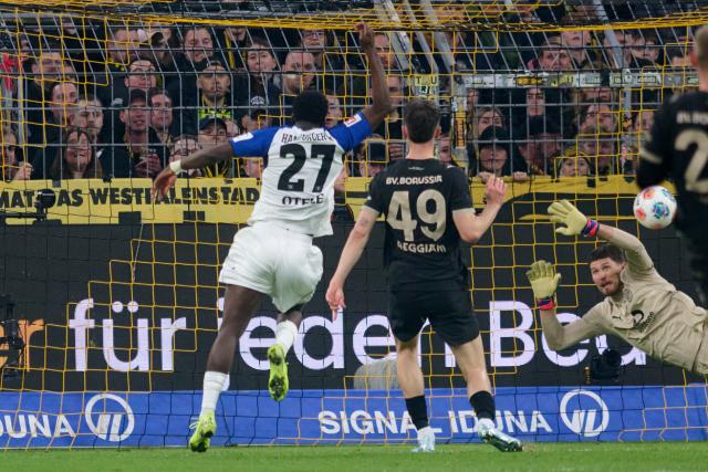 21 March 2026, North Rhine-Westphalia, Dortmund: Hamburger's Philip Otele (L) scores his side's first goal during the German Bundesliga soccer match between Borussia Dortmund and Hamburger SV at Signal Iduna Park. Photo: Bernd Thissen/dpa - WICHTIGER HINWEIS: Gemäß den Vorgaben der DFL Deutsche Fußball Liga bzw. des DFB Deutscher Fußball-Bund ist es untersagt, in dem Stadion und/oder vom Spiel angefertigte Fotoaufnahmen in Form von Sequenzbildern und/oder videoähnlichen Fotostrecken zu verwerten bzw. verwerten zu lassen.
