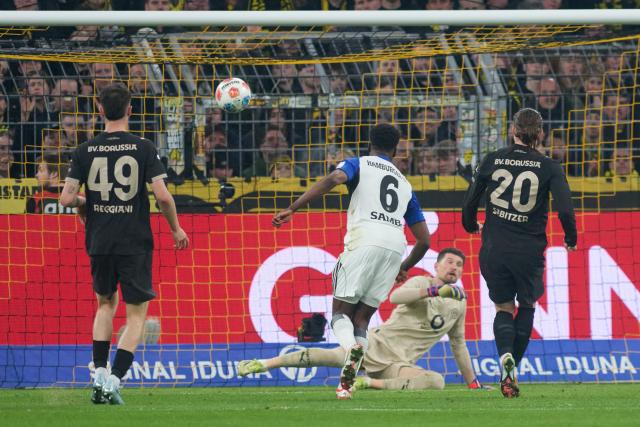 21 March 2026, North Rhine-Westphalia, Dortmund: Hamburger's Albert Lokonga (2nd L) scores his side's second goal during the German Bundesliga soccer match between Borussia Dortmund and Hamburger SV at Signal Iduna Park. Photo: Bernd Thissen/dpa - WICHTIGER HINWEIS: Gemäß den Vorgaben der DFL Deutsche Fußball Liga bzw. des DFB Deutscher Fußball-Bund ist es untersagt, in dem Stadion und/oder vom Spiel angefertigte Fotoaufnahmen in Form von Sequenzbildern und/oder videoähnlichen Fotostrecken zu verwerten bzw. verwerten zu lassen.