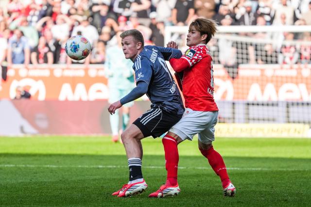 22 March 2026, Rhineland-Palatinate, Mainz: Eintracht Frankfurt's Jonathan Burkardt (L) and Mainz's Kaishu Sano (R) battle for the ball during the German Bundesliga soccer match between FSV Mainz 05 and Eintracht Frankfurt at the Mewa Arena. Photo: Marc Schüler/dpa - IMPORTANT NOTICE: DFL and DFB regulations prohibit any use of photographs as image sequences and/or quasi-video.