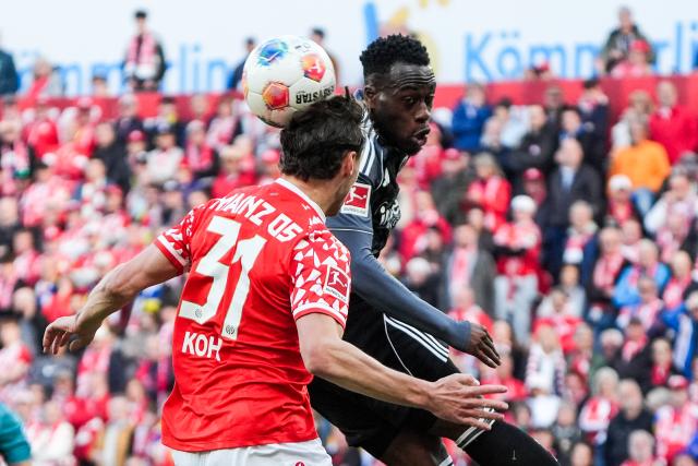 22 March 2026, Rhineland-Palatinate, Mainz: Mainz's Dominik Kohr (L) clears the ball with a header against Eintracht Frankfurt's Arnaud Kalimuendo (R) during the German Bundesliga soccer match between FSV Mainz 05 and Eintracht Frankfurt at the Mewa Arena. Photo: Marc Schüler/dpa - IMPORTANT NOTICE: DFL and DFB regulations prohibit any use of photographs as image sequences and/or quasi-video.