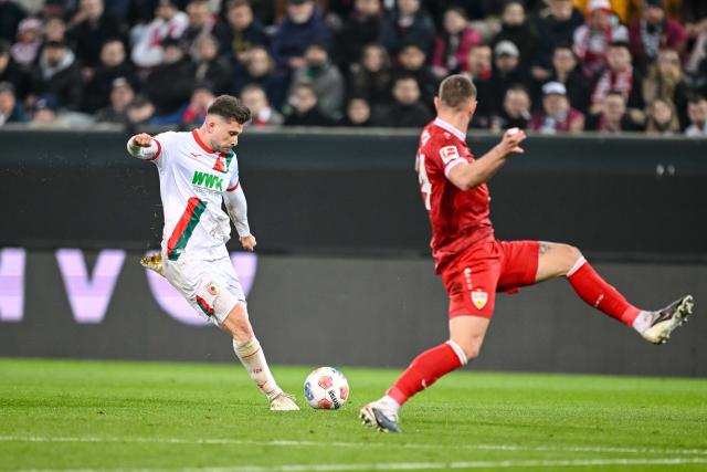 22 March 2026, Bavaria, Augsburg: Augsburg's Elvis Rexhbecaj (L) and Stuttgart's Jeff Chabot battle for the ball during the German Bundesliga soccer match between FC Augsburg and VfB Stuttgart at the Millerntor Stadium. Photo: Harry Langer/dpa - WICHTIGER HINWEIS: Gemäß den Vorgaben der DFL Deutsche Fußball Liga bzw. des DFB Deutscher Fußball-Bund ist es untersagt, in dem Stadion und/oder vom Spiel angefertigte Fotoaufnahmen in Form von Sequenzbildern und/oder videoähnlichen Fotostrecken zu verwerten bzw. verwerten zu lassen.