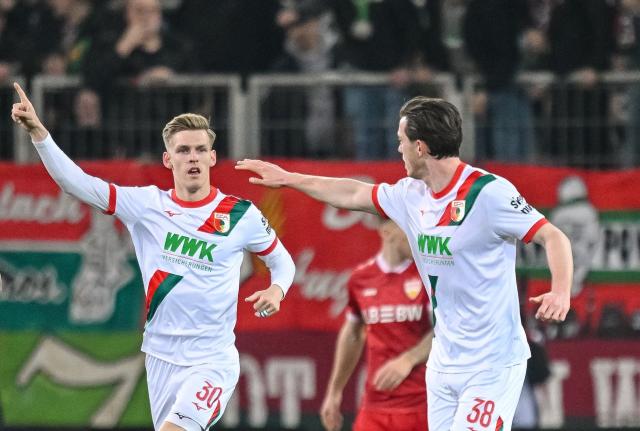 22 March 2026, Bavaria, Augsburg: Augsburg's Anton Kade (L) celebrates his side's second goal of the game during the German Bundesliga match between FC Augsburg and VfB Stuttgart at the Millerntor Stadium. Photo: Harry Langer/dpa - WICHTIGER HINWEIS: Gemäß den Vorgaben der DFL Deutsche Fußball Liga bzw. des DFB Deutscher Fußball-Bund ist es untersagt, in dem Stadion und/oder vom Spiel angefertigte Fotoaufnahmen in Form von Sequenzbildern und/oder videoähnlichen Fotostrecken zu verwerten bzw. verwerten zu lassen.