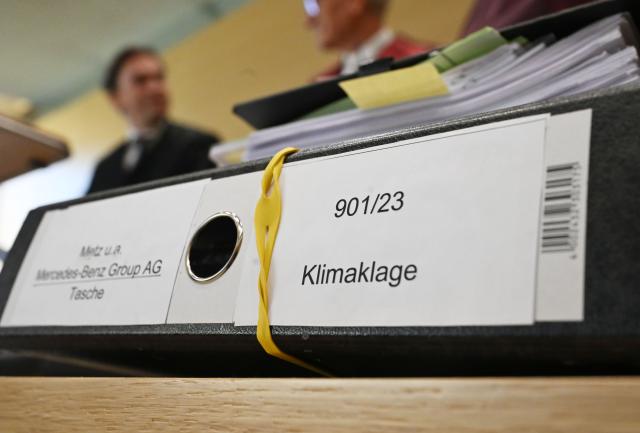 FILED - 02 March 2026, Baden-Württemberg, Karlsruhe: A file folder labeled "climate lawsuit" and Mercedes-Benz Group AG lies on a table in a courtroom of the German Court of Justice (BGH). Germany's Federal Court of Justice will rule on Monday in two climate lawsuits filed against automotive giants BMW and Mercedes-Benz. Photo: Uli Deck/dpa
