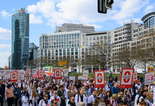 23 March 2026, Berlin: Demonstrators carry signs during their protest march from Potsdamer Platz to Rotes Rathaus. Photo: Soeren Stache/dpa