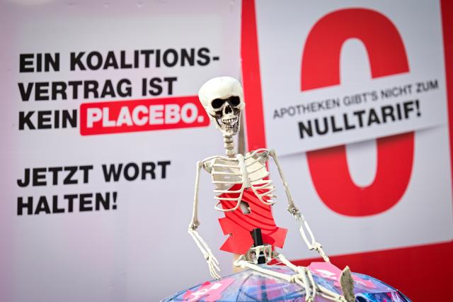 23 March 2026, Berlin: Demonstrators carry signs reading "A coalition agreement is not a placebo" and a skeleton during their protest march from Potsdamer Platz to Rotes Rathaus. Photo: Soeren Stache/dpa