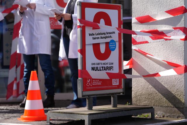 23 March 2026, Hamburg: Female employees stand in front of the cordoned-off entrance to a pharmacy on the nationwide pharmacy protest day. Pharmacies are called upon to keep their stores closed on the day of protest by pharmacies for higher pay. Photo: Marcus Brandt/dpa