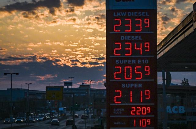 23 March 2026, Berlin: The current prices for petrol and diesel are shown on a petrol station display board at sunrise. Photo: Jens Kalaene/dpa