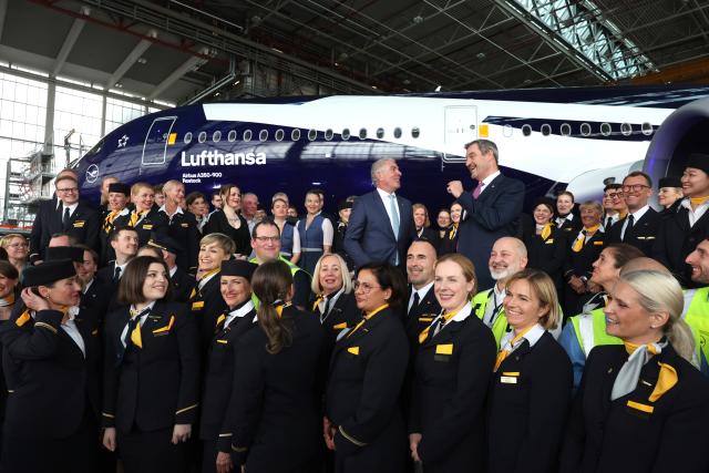 23 March 2026, Bavaria, Munich: Bavarian Minister President Markus Soeder and Carsten Spohr, Chairman of the Executive Board of Deutsche Lufthansa, stand together with Lufthansa employees in front of the Airbus A350-900 Rostock on the occasion of Lufthansa's 100th anniversary celebrations. Photo: Karl-Josef Hildenbrand/dpa