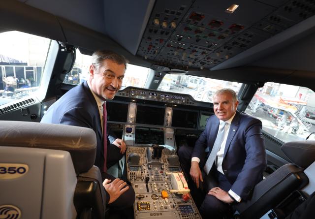 23 March 2026, Bavaria, Munich: Markus Soeder (L), Bavarian Minister President and Carsten Spohr, CEO of Deutsche Lufthansa, sit in the cockpit of the Airbus A350-900 Rostock on the occasion of Lufthansa's 100th anniversary celebration. Photo: Karl-Josef Hildenbrand/dpa