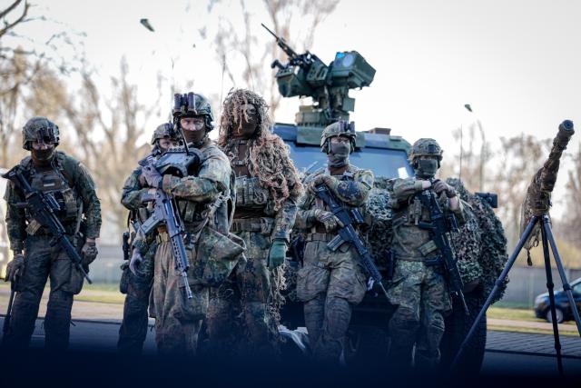 23 March 2026, Berlin: Bundeswehr soldiers of the guard battalion await the German Chancellor at the presentation of the flag ribbon. Photo: Kay Nietfeld/dpa