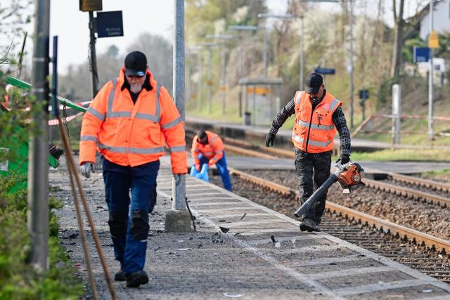 24 March 2026, Rhineland-Palatinate, Insheim: Deutsche Bahn employees remove the traces of the accident at the station, where several people have been injured in a collision between a regional train and a car transporter in the Southern Palatinate. Photo: Uwe Anspach/dpa