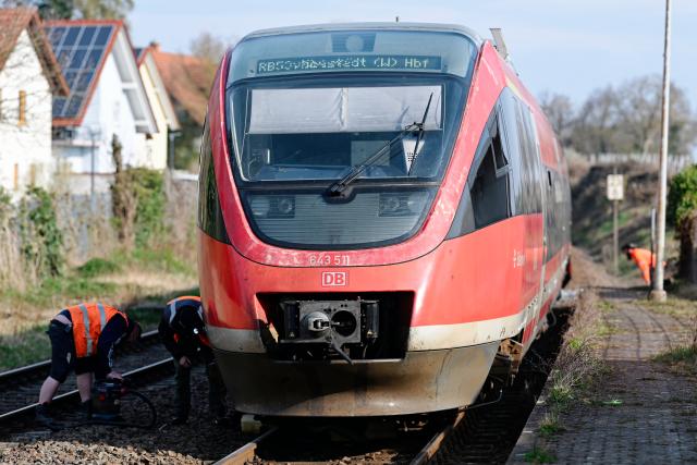 24 March 2026, Rhineland-Palatinate, Insheim: Deutsche Bahn employees stand by a regional train at the station, where several people have been injured in a collision between a regional train and a car transporter in the Southern Palatinate. Photo: Uwe Anspach/dpa
