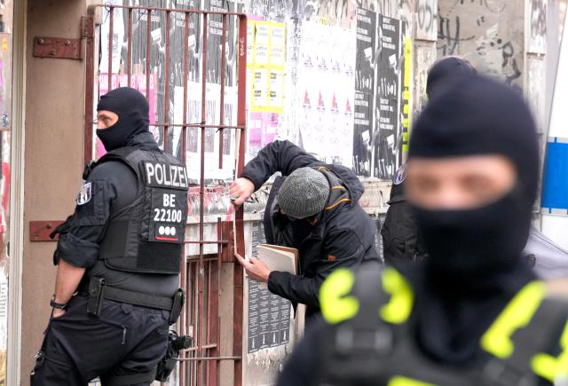 24 March 2026, Berlin: Police officers stand in front of the Kalabalik bookshop on Reichenberger Strasse.  Six months after an arson attack on the power supply to Berlin's Adlershof Technology Park, the police have launched a raid against suspects. Photo: Soeren Stache/dpa