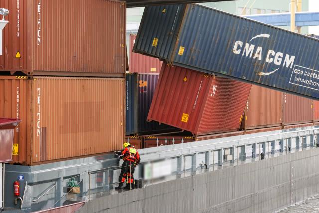 24 March 2026, North Rhine-Westphalia, Neuss: A container ship is docked at the Port of Neuss after colliding with a bridge, causing several containers to fall into the water. Photo: Jan Ohmen/dpa - ACHTUNG: Einige Schriftzüge und Personen wurde(n) aus rechtlichen Gründen gepixelt