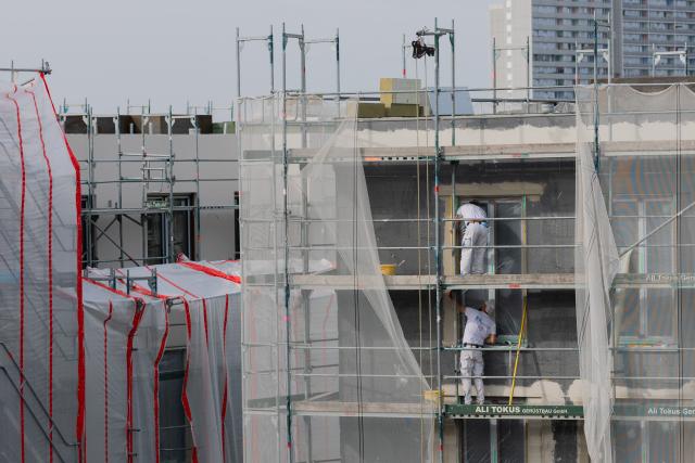 FILED - 24 March 2026, North Rhine-Westphalia, Cologne: Construction workers plaster an insulated facade on a building site for privately financed owner-occupied apartments. Photo: Rolf Vennenbernd/dpa