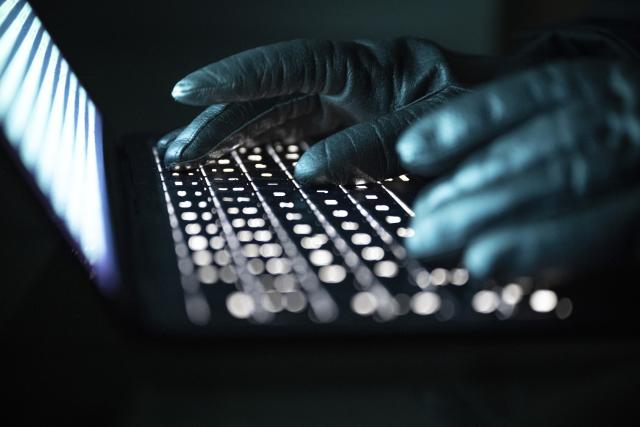 FILED - 14 December 2025, Berlin: A person types with gloved hands on an illuminated laptop keyboard. Photo: Philip Dulian/dpa