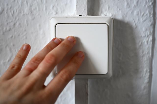 FILED - 05 March 2026, Berlin: A woman operates a light switch on a wall. Photo: Elisa Schu/dpa