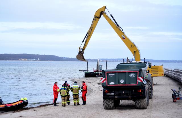 26 March 2026, Schleswig-Holstein, Timmendorfer Strand: Rescuers are standing on the beach near the stranded whale. A new rescue attempt for the animal is scheduled for today. Photo: Daniel Bockwoldt/dpa