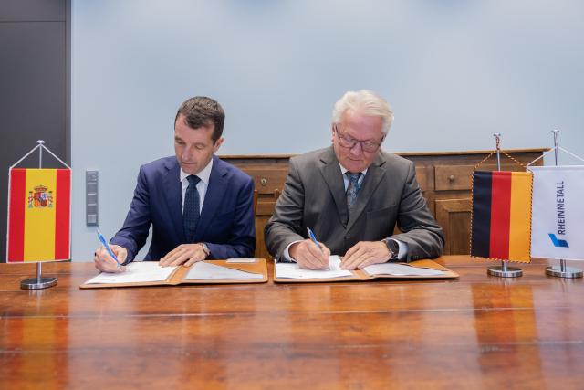 PRODUCTION - 26 March 2026, North Rhine-Westphalia, Duesseldorf: CEO of Rheinmetall AG Armin Papperger (R) and CEO of the Spanish technology company Indra Angel Escribano sign a memorandum of understanding to expand their strategic cooperation in the field of military vehicle systems. Photo: Rolf Vennenbernd/dpa