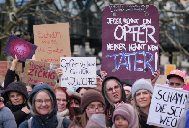26 March 2026, Hamburg: People hold up signs at Town Hall Square during a demonstration against sexual violence targeting women. Photo: Marcus Brandt/dpa