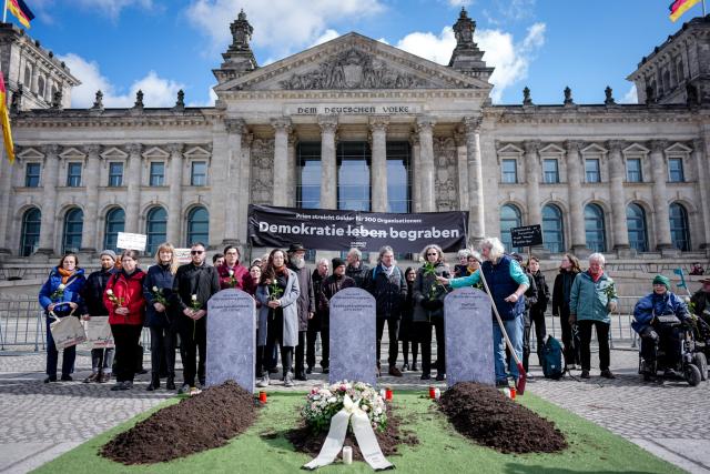 27 March 2026, Berlin: Demonstrate with the campaign organization Campact in front of the Reichstag building against the cancellation of funding programmes, during the  German Parliament (Bundestag) session on the subject of "Living democracy - protecting commitment, maintaining funding structures". Photo: Kay Nietfeld/dpa