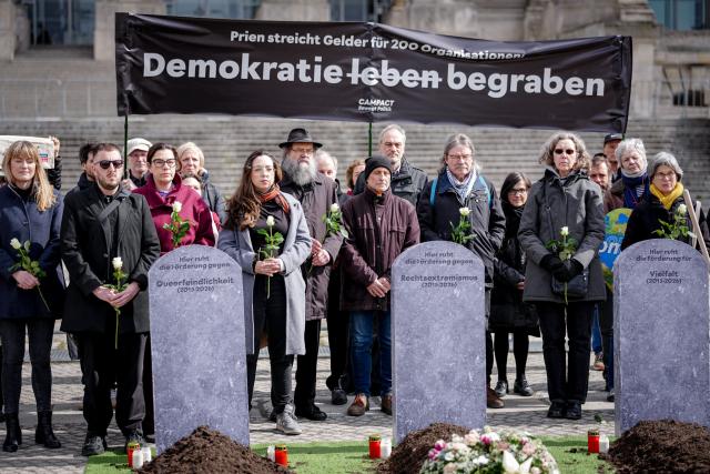 27 March 2026, Berlin: Demonstrate with the campaign organization Campact in front of the Reichstag building against the cancellation of funding programmes, during the  German Parliament (Bundestag) session on the subject of "Living democracy - protecting commitment, maintaining funding structures". Photo: Kay Nietfeld/dpa