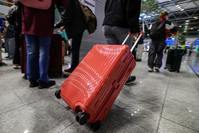 28 March 2026, North Rhine-Westphalia, Duesseldorf: A woman is pulling her suitcase, at the start of the Easter break in North Rhine-Westphalia. Photo: Christoph Reichwein/dpa