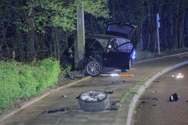 28 March 2026, North Rhine-Westphalia, Wuppertal: A car lies completely wrecked against a streetlight, with car parts scattered across the street. Photo: Christoph Petersen/dpa