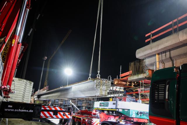 28 March 2026, North Rhine-Westphalia, Oberhausen: A prefabricated component measuring 41 meters in length is lifted from a heavy-duty transport vehicle and positioned correctly using several cranes. Photo: Christoph Reichwein/dpa