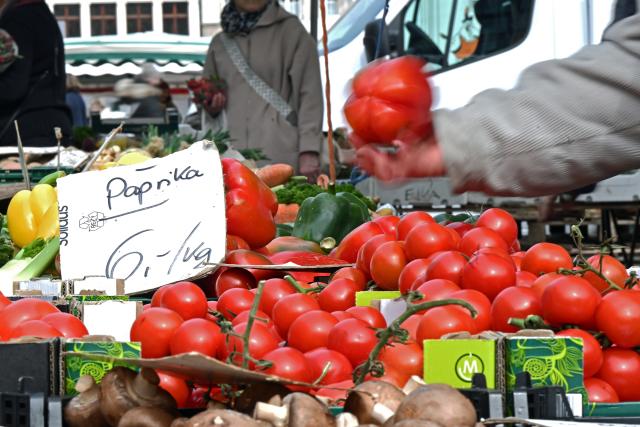 FILED - 24 March 2026, Saxony, Leipzig: A woman reaches for peppers labeled "6 euros/kg" at a market stall. Photo: Jennifer Brückner/dpa
