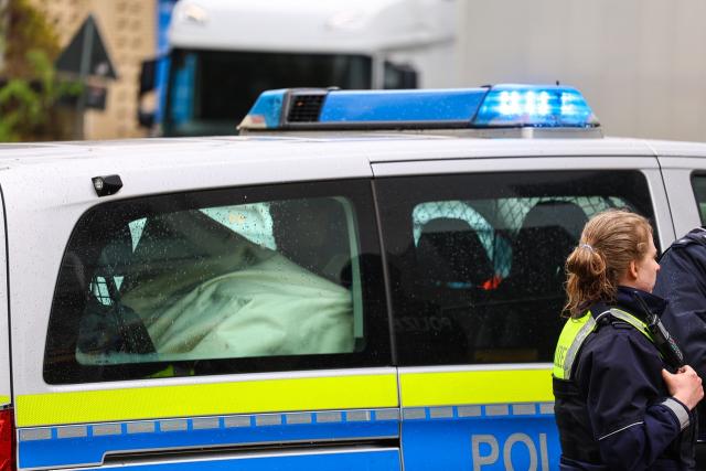 28 March 2026, North Rhine-Westphalia, Witten: A policewoman stands next to a patrol car during a large-scale operation in Witten. A boy was killed in a violent altercation in the city in North Rhine-Westphalia. Photo: Alex Talash/dpa