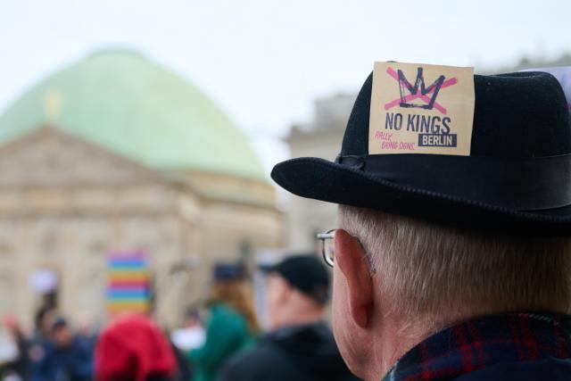 28 March 2026, Berlin: A sticker reading 'No Kings Berlin' is seen on a protester's hat on Bebelplatz during a demonstration against the Trump administration. Protests against President Donald Trump's policies are taking place in Germany as well as in many US cities and other locations worldwide. Photo: Annette Riedl/dpa