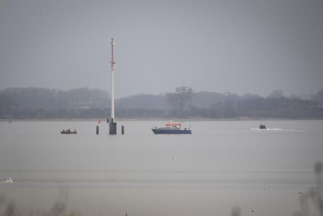 28 March 2026, Mecklenburg-Western Pomerania, Boltenhagen: The 'Uecker,' a water police boat, and several inflatable boats are stationed at a distance from a humpback whale in Wismar Bay. The whale, which had been freed off Timmendorfer Strand, has become stranded again and is now lying on a sandbar. Photo: Philip Dulian/dpa