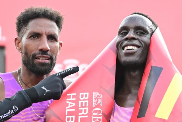 29 March 2026, Berlin: fastest German and third-placed Amanal Petros (L) stands next to his pacemaker Dennis Kipkemoi after the Berlin Half Marathon. Photo: Sebastian Christoph Gollnow/dpa