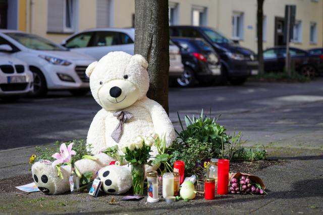 29 March 2026, North Rhine-Westphalia, Witten: Mourners have placed a large teddy bear, flowers, and candles in front of the knife attack victims' home in memory of the 13-year-old boy who died, his mother, who suffered life-threatening injuries, and his sister, who was also critically injured. Photo: Christoph Reichwein/dpa