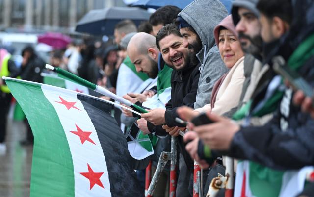 30 March 2026, Berlin: Participants hold Syrian flags during a pro-Syrian rally in conjunction with Syria's interim president Ahmed al-Sharaa visit to Berlin. Photo: Elisa Schu/dpa