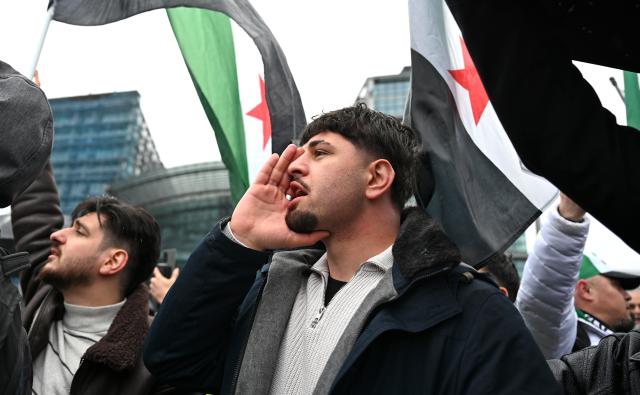 30 March 2026, Berlin: Participants hold Syrian flags during a pro-Syrian rally in conjunction with Syria's interim president Ahmed al-Sharaa visit to Berlin. Photo: Elisa Schu/dpa