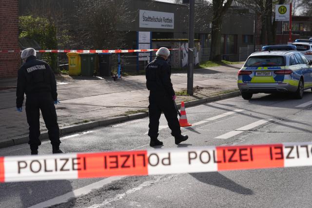 30 March 2026, Hamburg: Forensic investigators examine the crime scene following a knife attack outside the Flottbek neighborhood school. Photo: Marcus Brandt/dpa