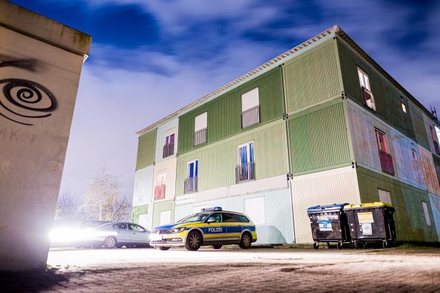 30 March 2026, Lower Saxony, Hanover: A police vehicle is parked outside a refugee shelter in the Vahrenheide neighborhood. A woman in Hanover has suffered life-threatening injuries from a stabbing. Photo: Moritz Frankenberg/dpa