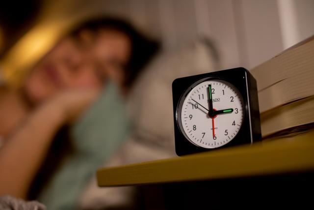 FILED - 27 October 2021, Berlin: A woman sleeps next to an alarm clock. Photo: Christoph Soeder/dpa