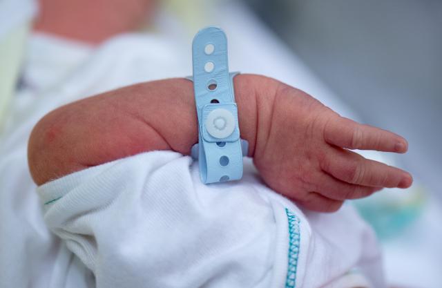 FILED - 22 August 2016, Saxony, Dresden: A newborn lies in a bed at university hospital Carl Gustav Carus in Dresden. Photo: Arno Burgi/dpa-Zentralbild/dpa